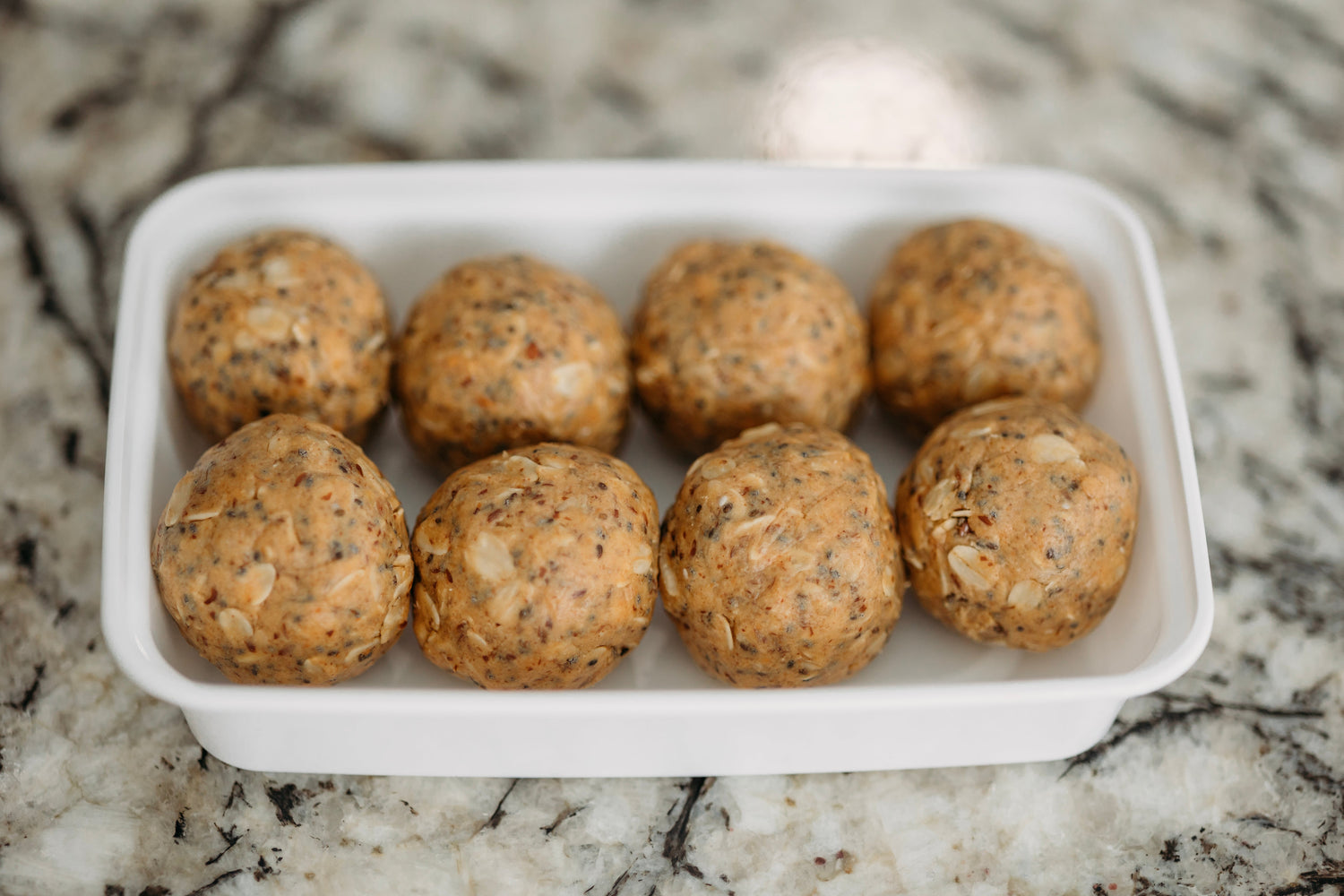 High-protein snack balls neatly arranged in a container for convenient and easy meal planning.